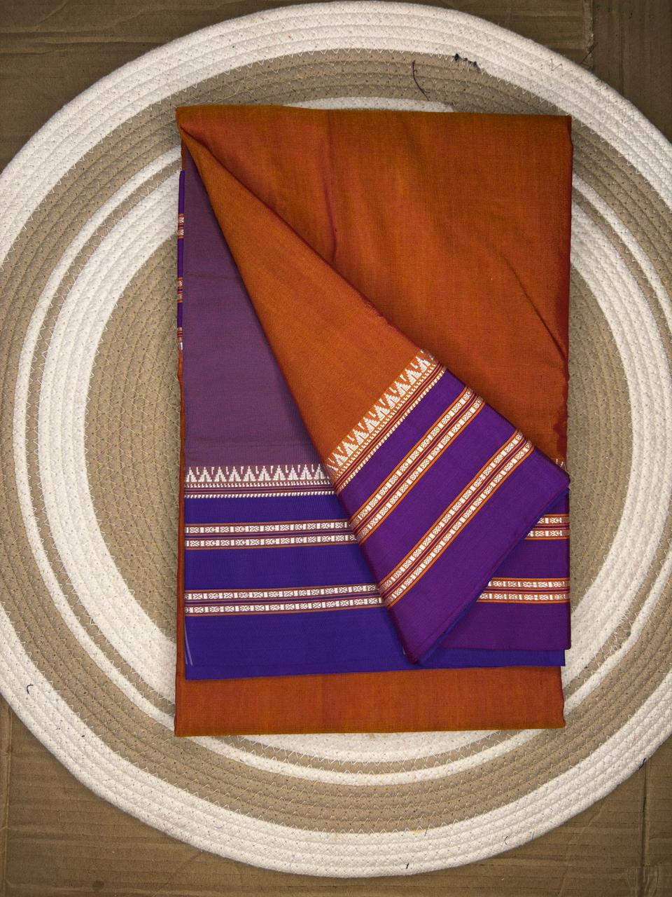 Folded fabric with purple and orange pattern on a circular woven mat