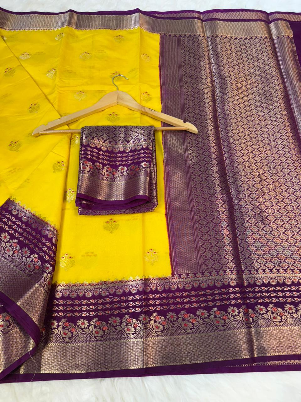 Yellow saree with purple and silver border on a white background