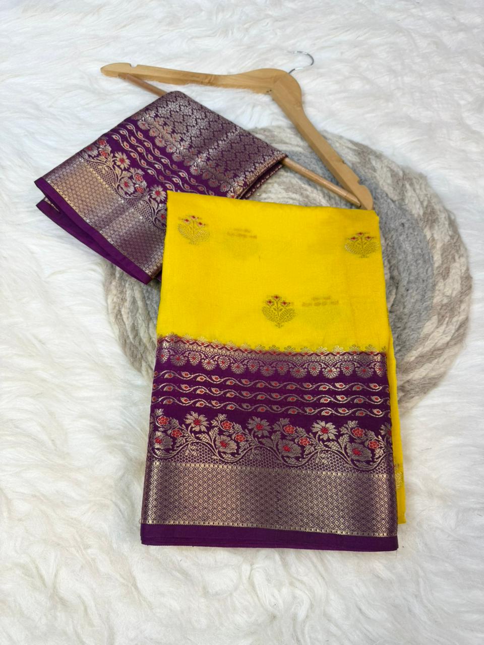 Yellow and purple saree with a hanger on a white background