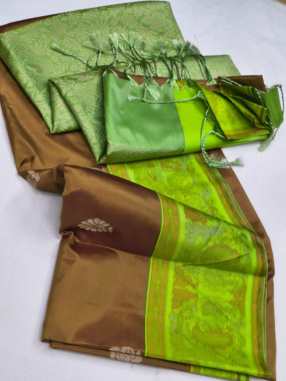 Green and brown saree with decorative patterns on a white background