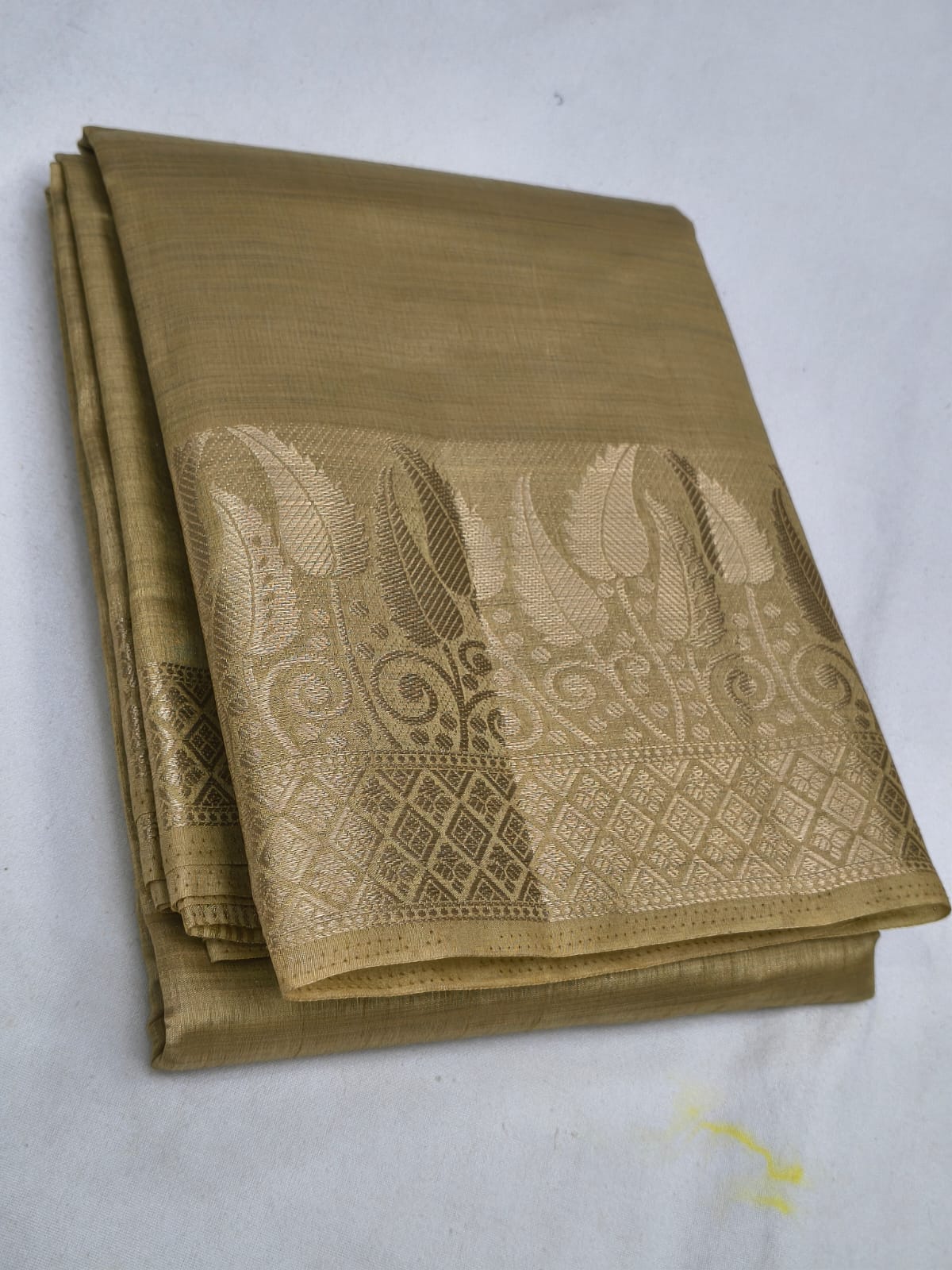 Folded brown fabric with intricate patterns on a white background