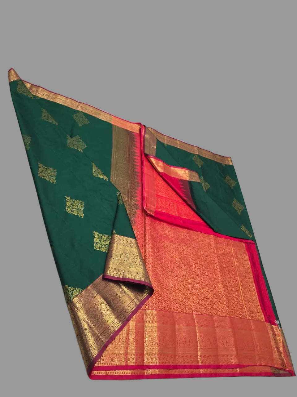 Green and orange saree with gold border on a white background