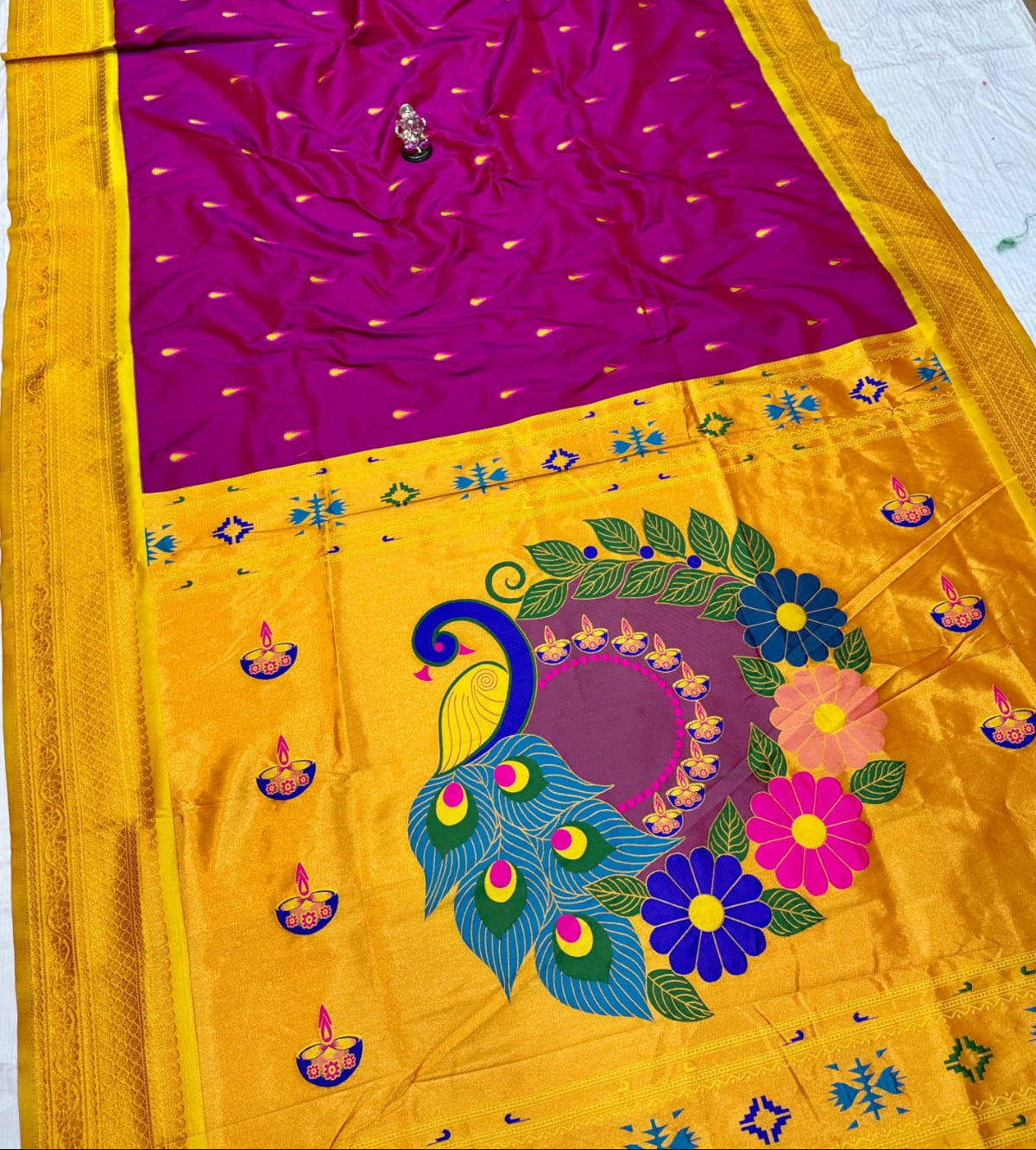 Yellow saree with purple blouse featuring peacock and floral designs.