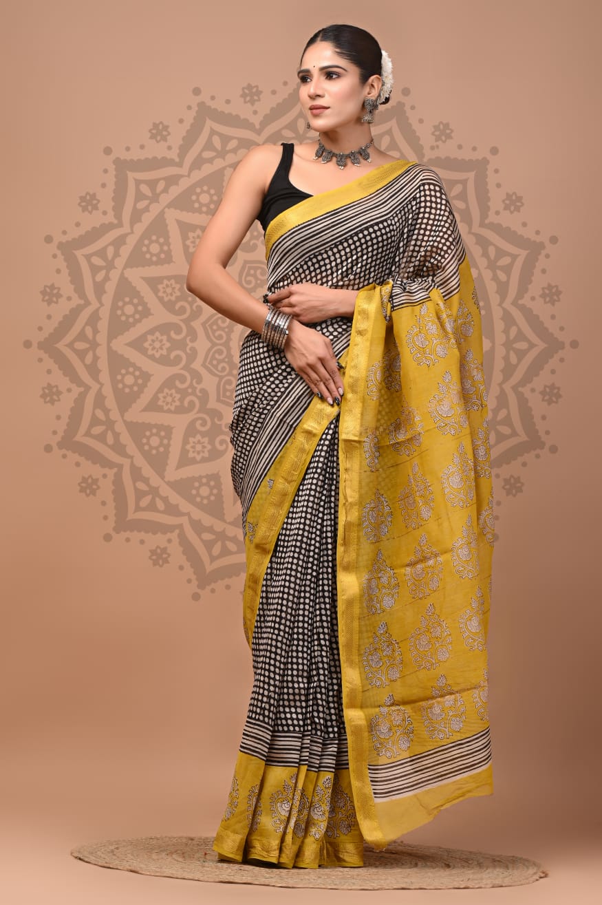 Woman wearing a yellow and black saree with a decorative background