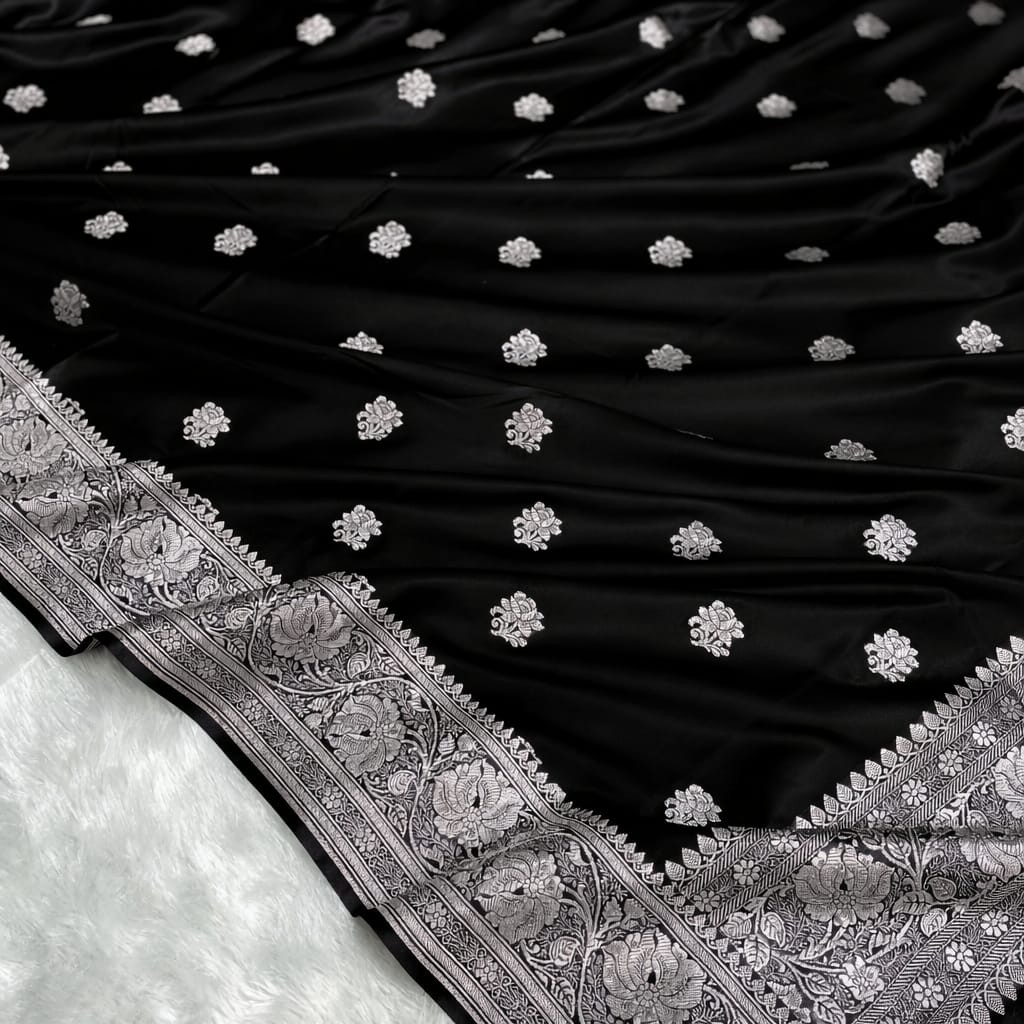 Black fabric with white floral patterns and intricate silver embroidery