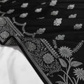 Black fabric with silver floral embroidery on a white background