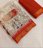 Textile with bird design and red border, next to a gold figurine on a light background