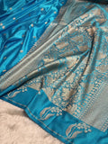 Blue saree with intricate silver patterns on a white background