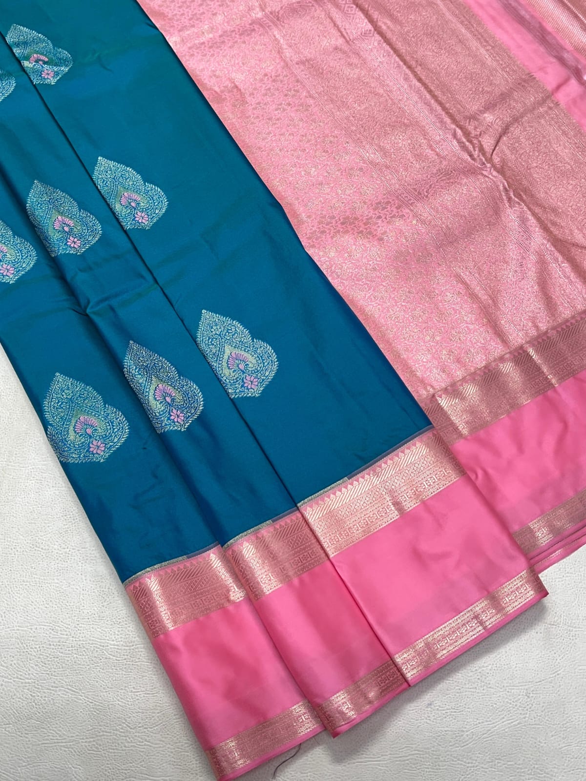 Blue and pink saree with intricate patterns on a white background