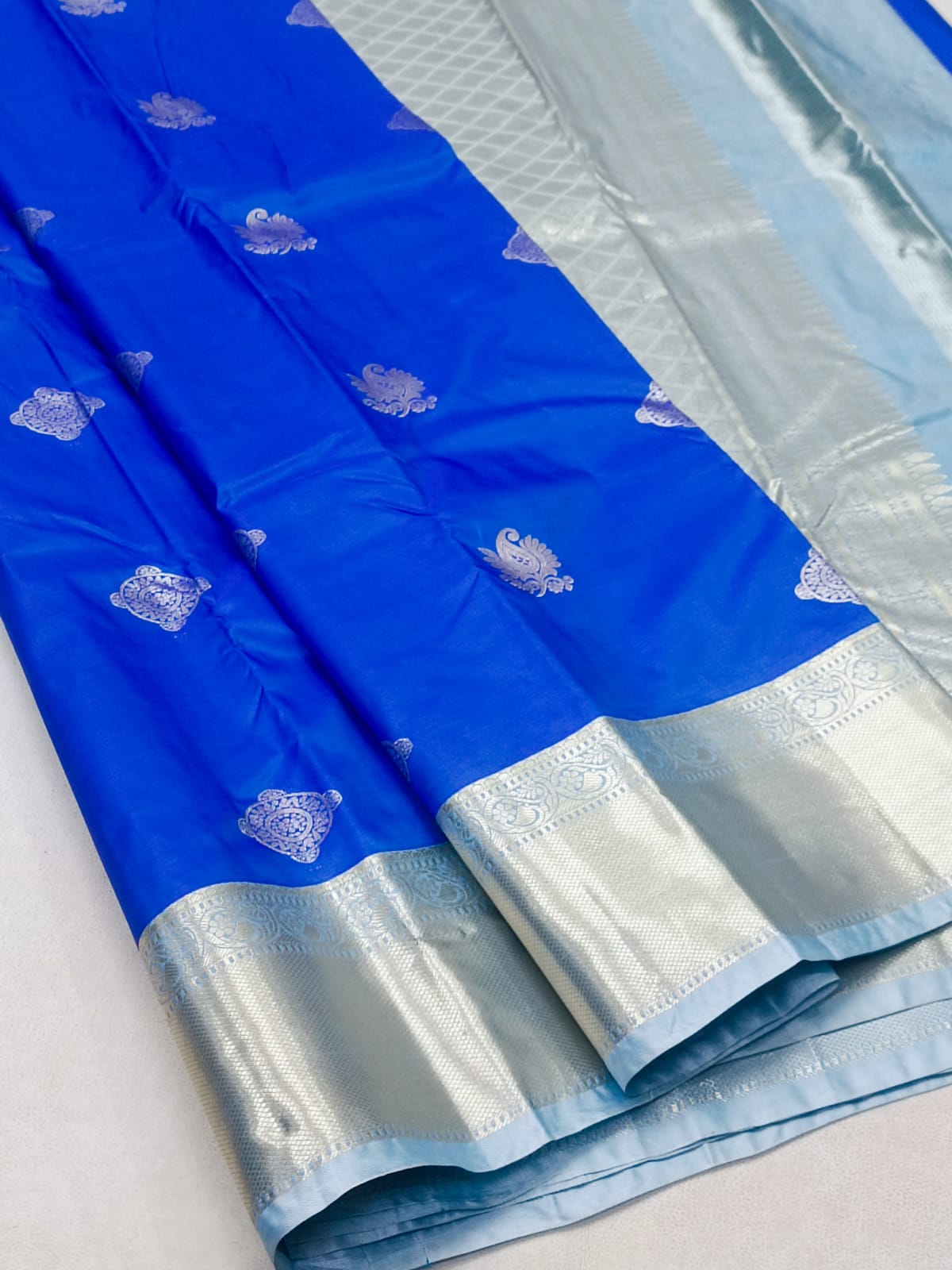 Blue and white saree with a subtle pattern on a light gray background