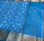 Blue saree with white floral patterns on a red surface