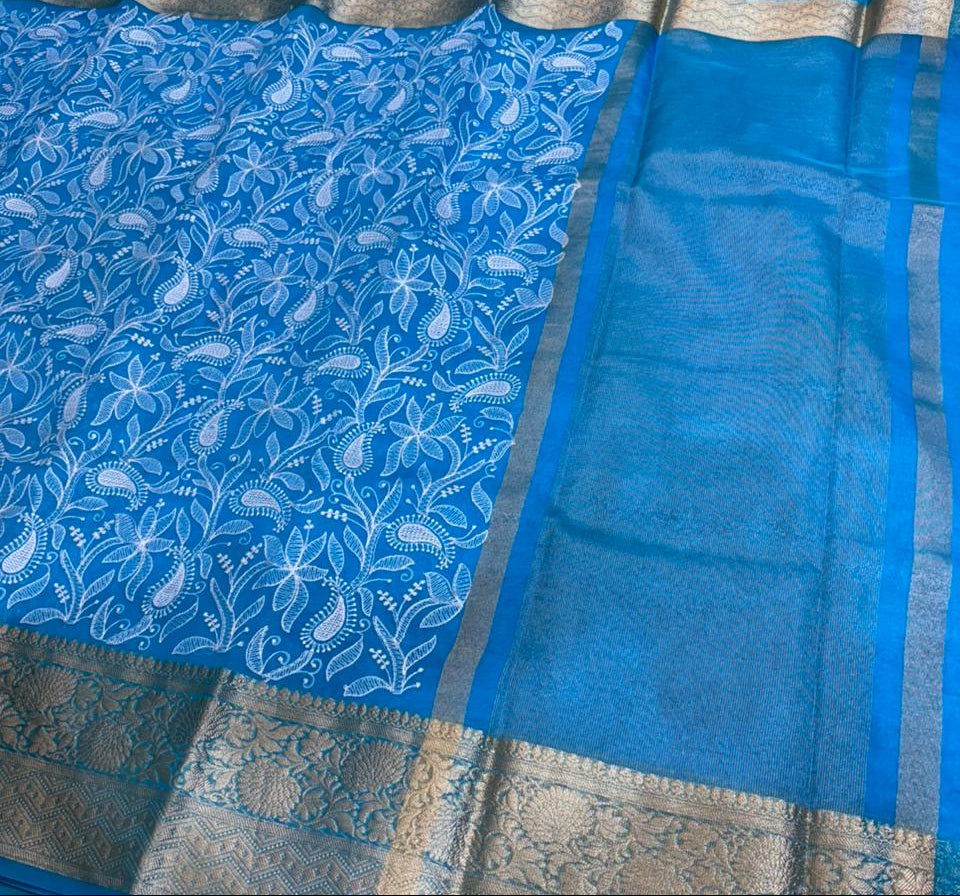 Blue saree with white floral patterns on a red surface