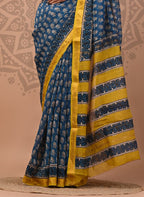 Woman wearing a blue and yellow saree with a decorative background