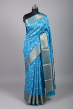 Blue saree with white floral patterns on a red surface