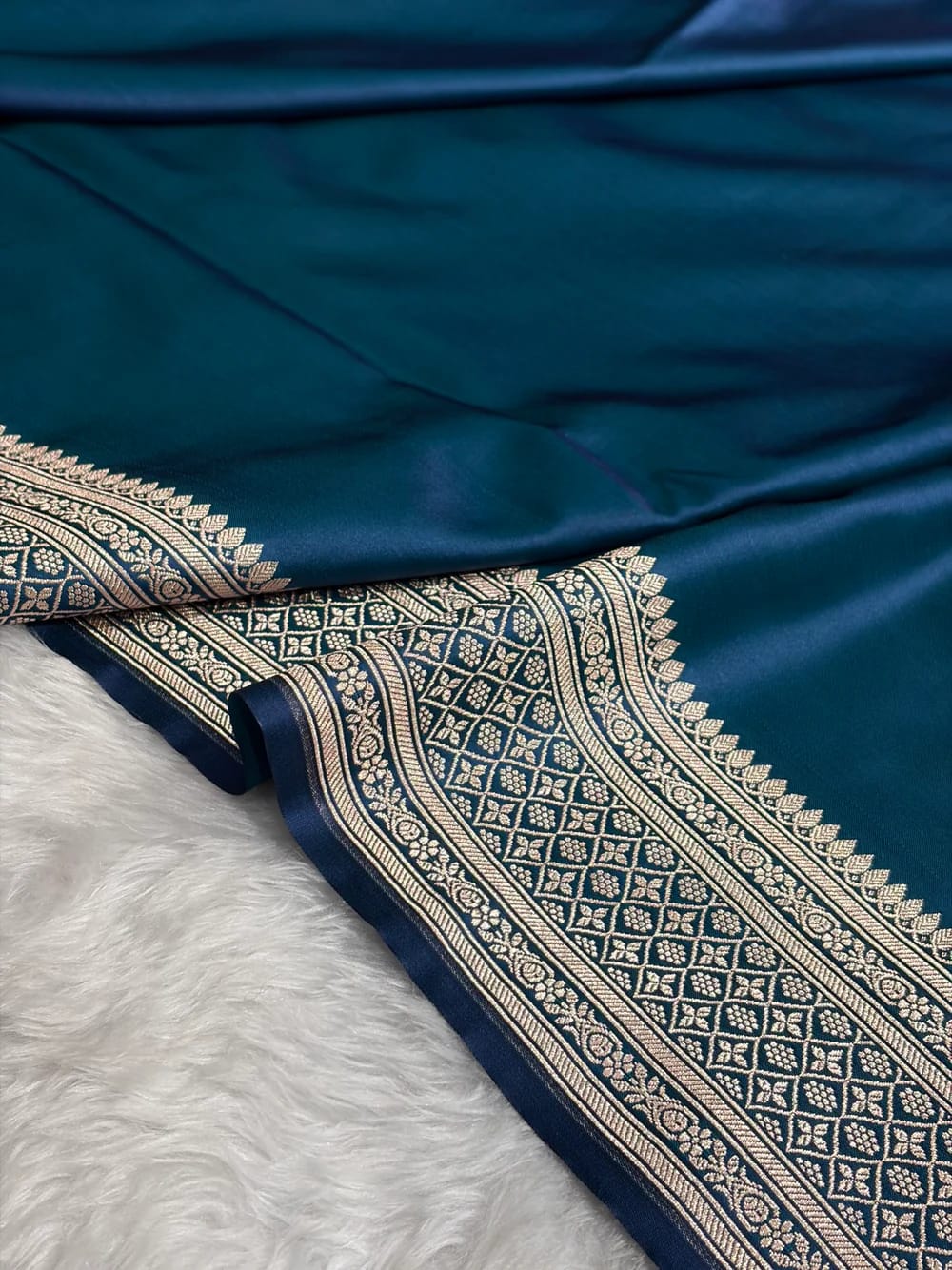 Blue fabric with intricate gold patterns on a white background