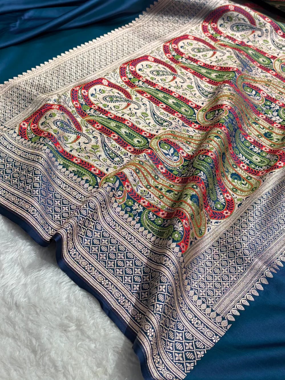 Colorful patterned fabric with intricate designs on a blue background