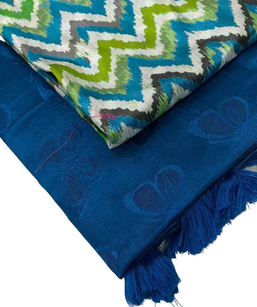 Blue saree with embroidered patterns and a colorful fabric above on a light background