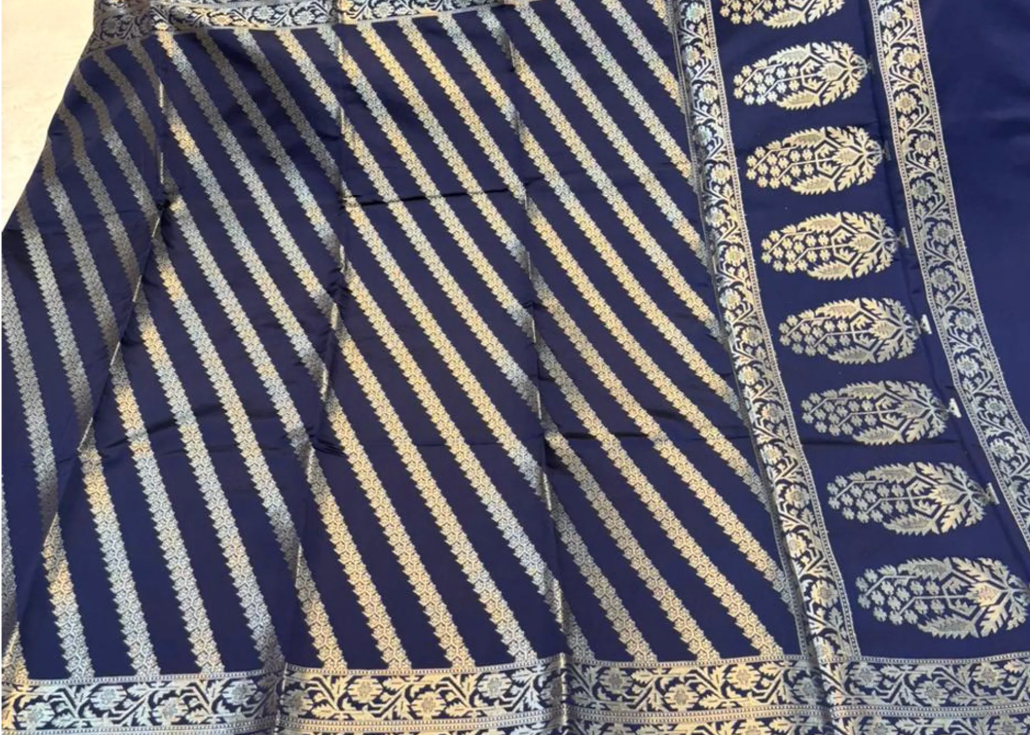 A navy blue saree with silver metallic Banarasi stripes and a wide border featuring silver floral motifs.
