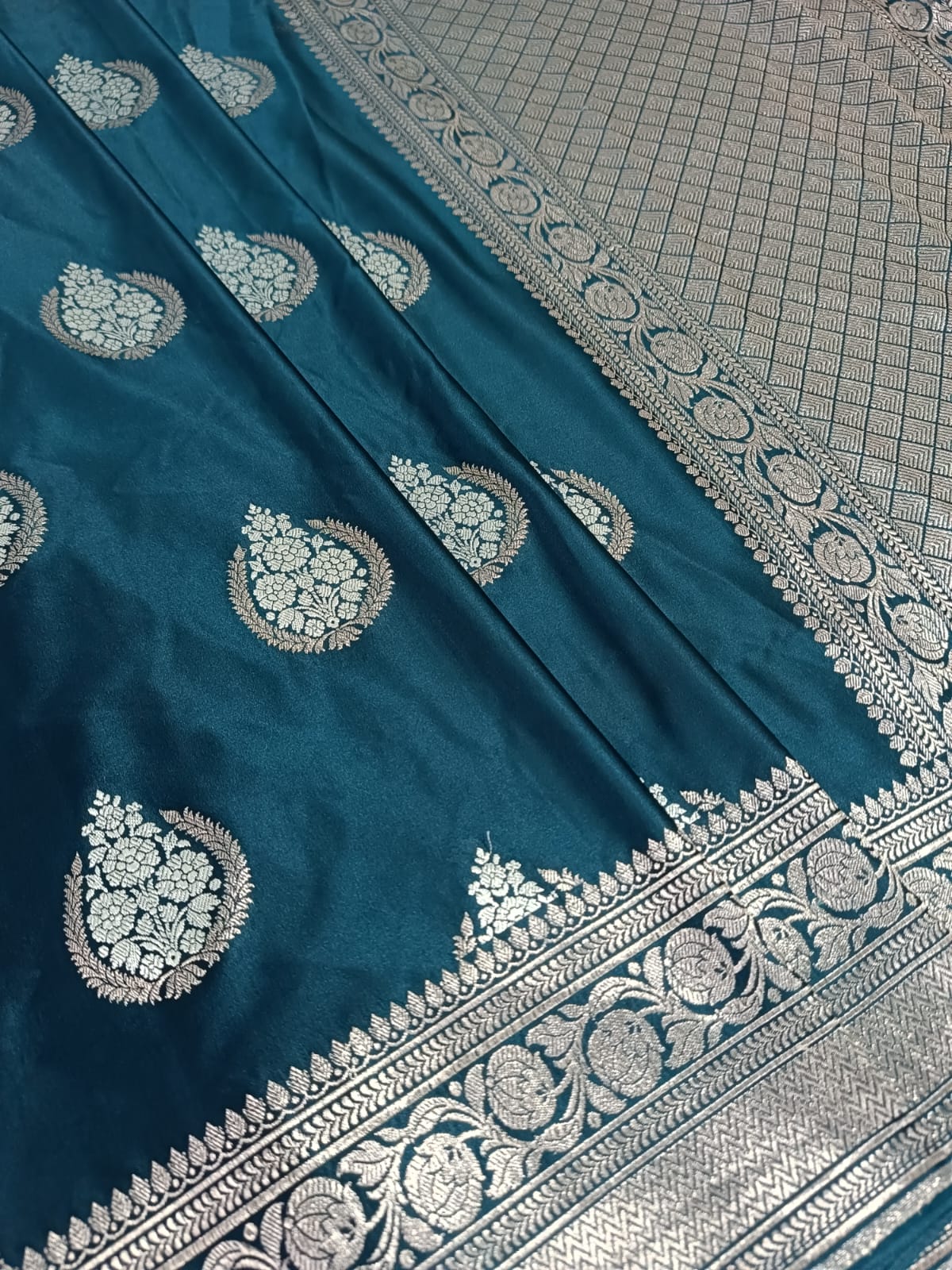 Teal fabric with silver embroidery on a checkered background