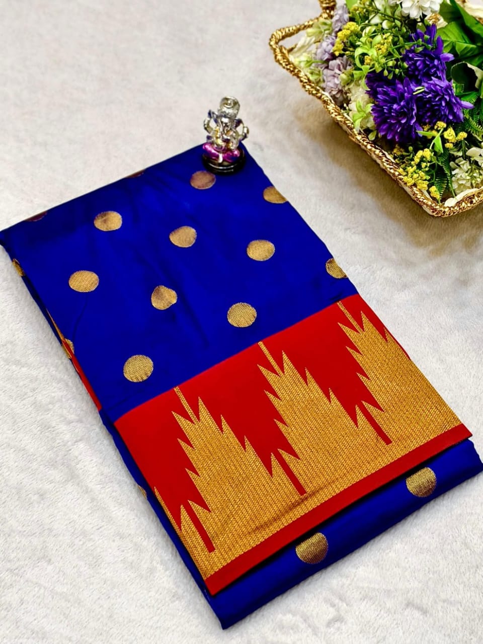 Blue and red saree with gold patterns on a white surface