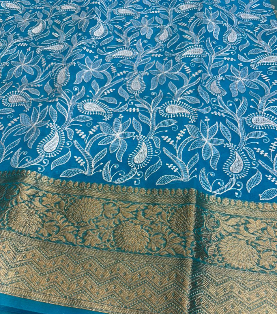 Blue saree with white floral patterns and gold border