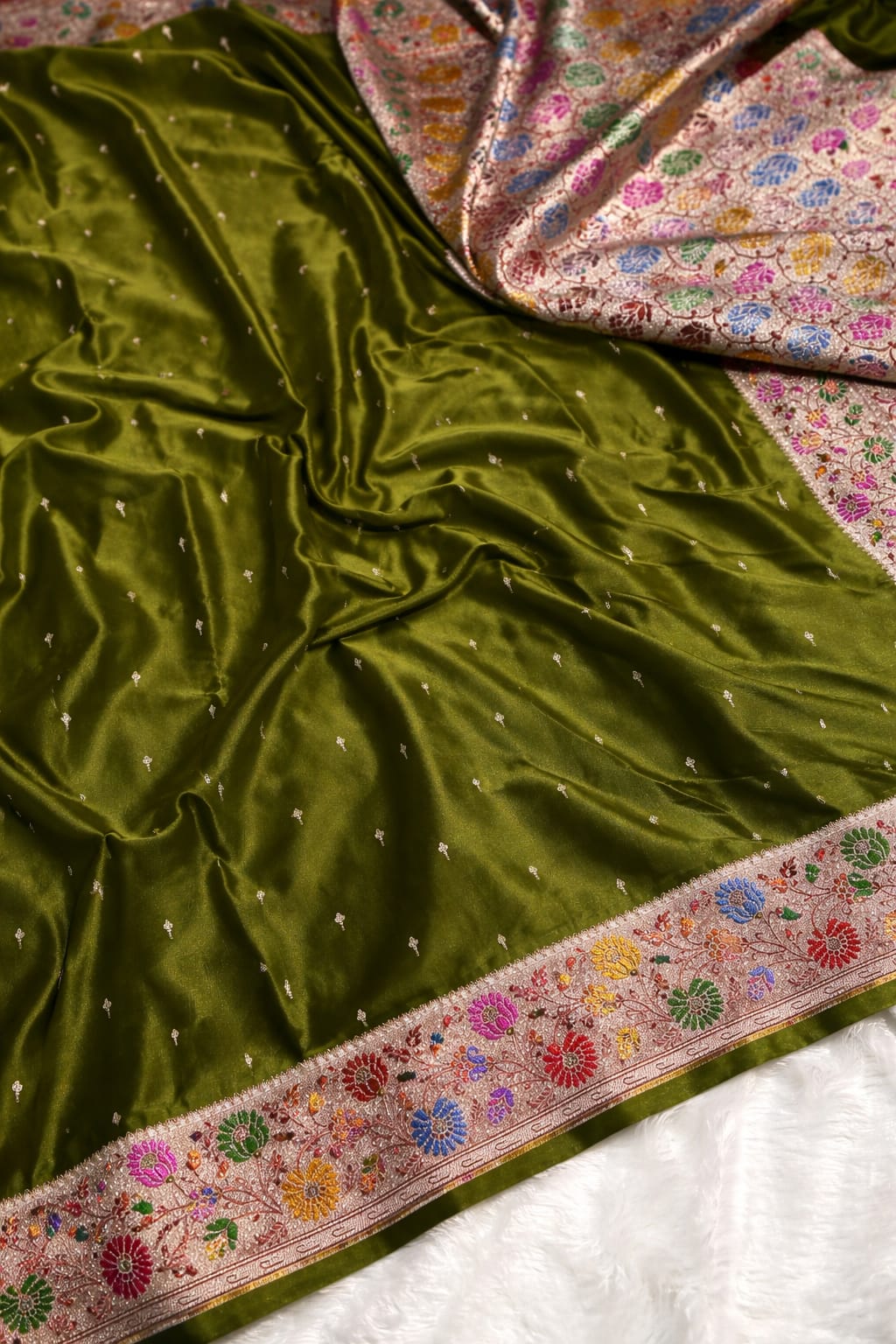 Green fabric with floral patterns on a textured surface