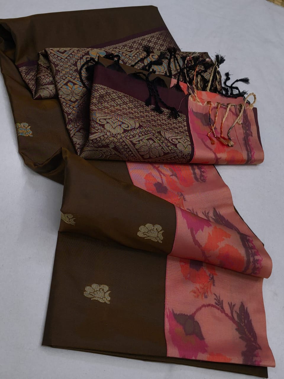 Brown and pink patterned fabric with decorative elements on a white background