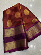 Maroon and purple saree with gold patterns on a marble floor