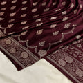 Maroon fabric with intricate gold patterns on a white background