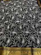 Black fabric with white floral pattern and gold border