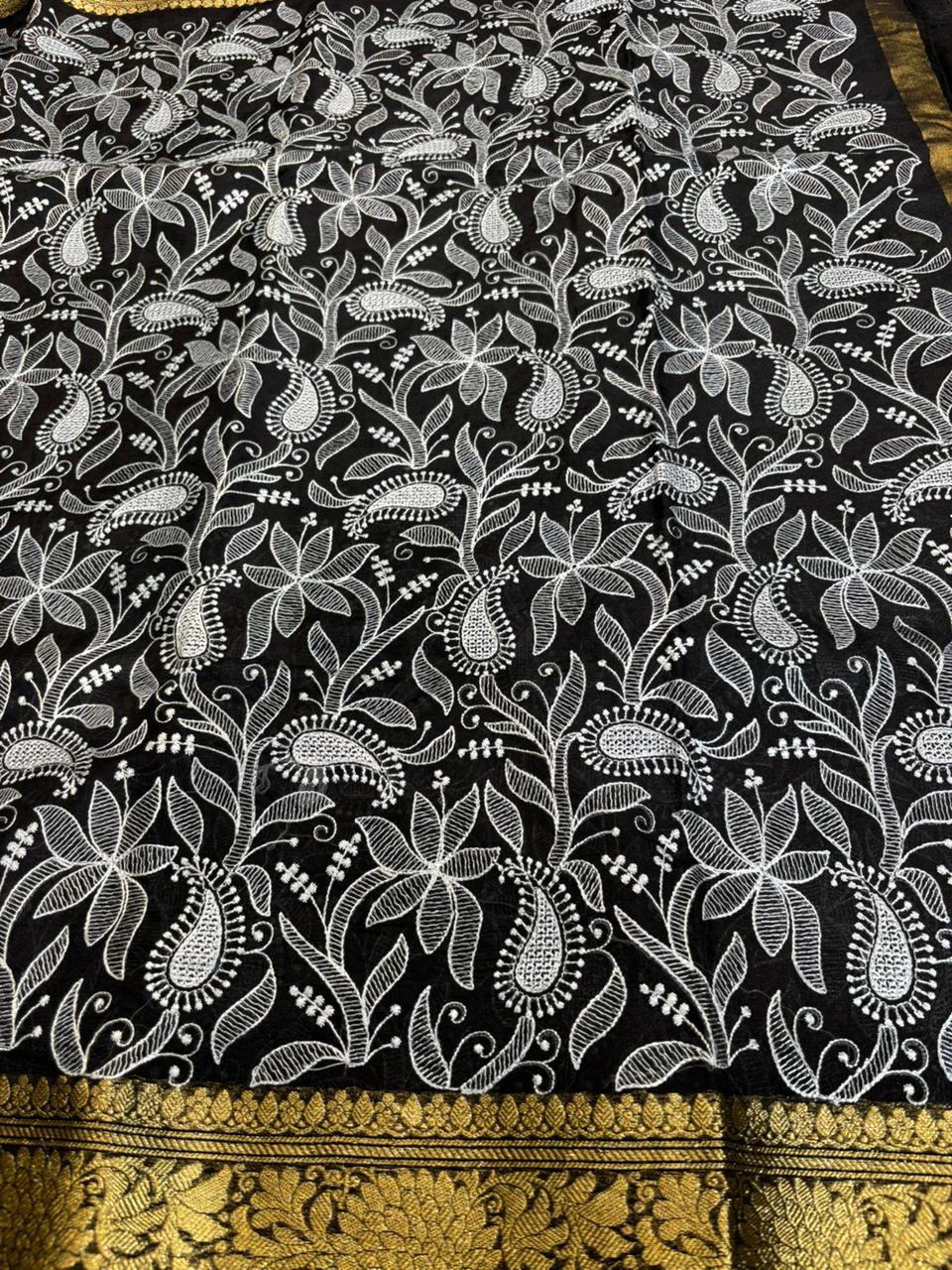 Black fabric with white floral pattern and gold border
