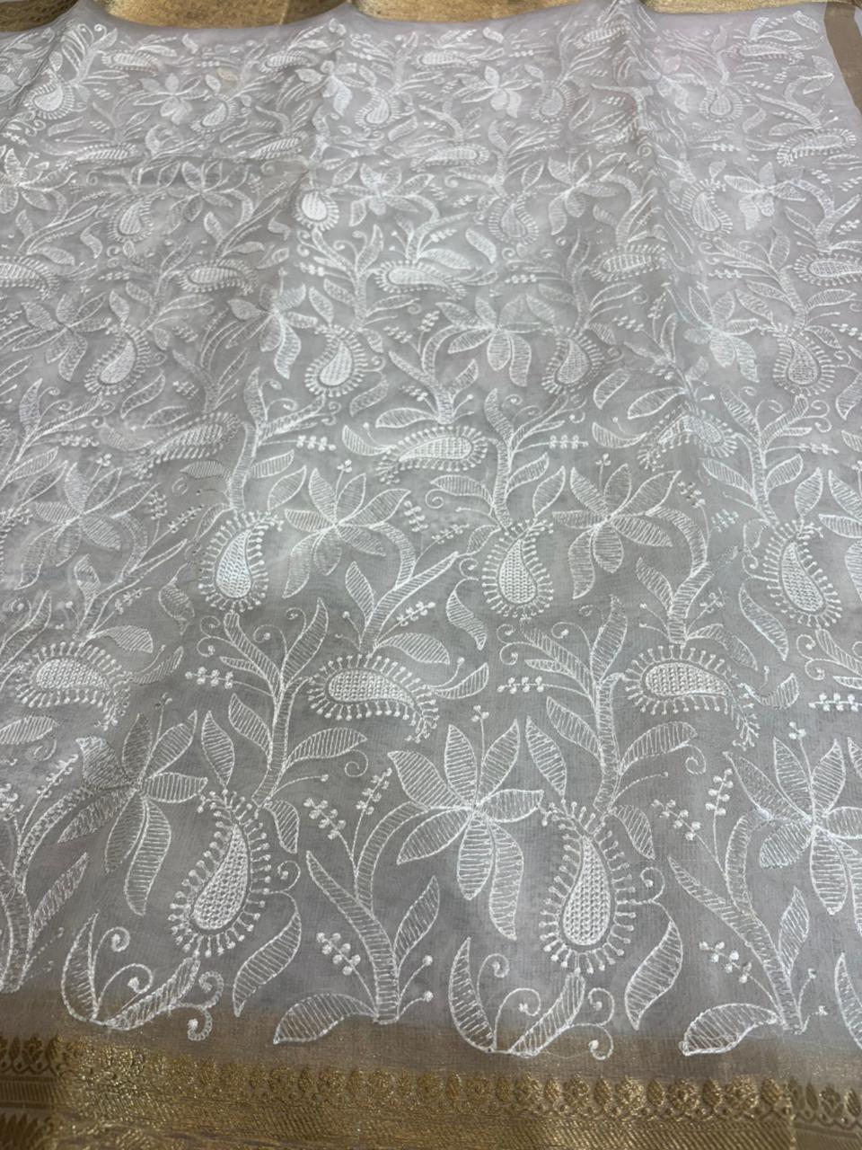 White lace fabric with floral patterns on a gold border