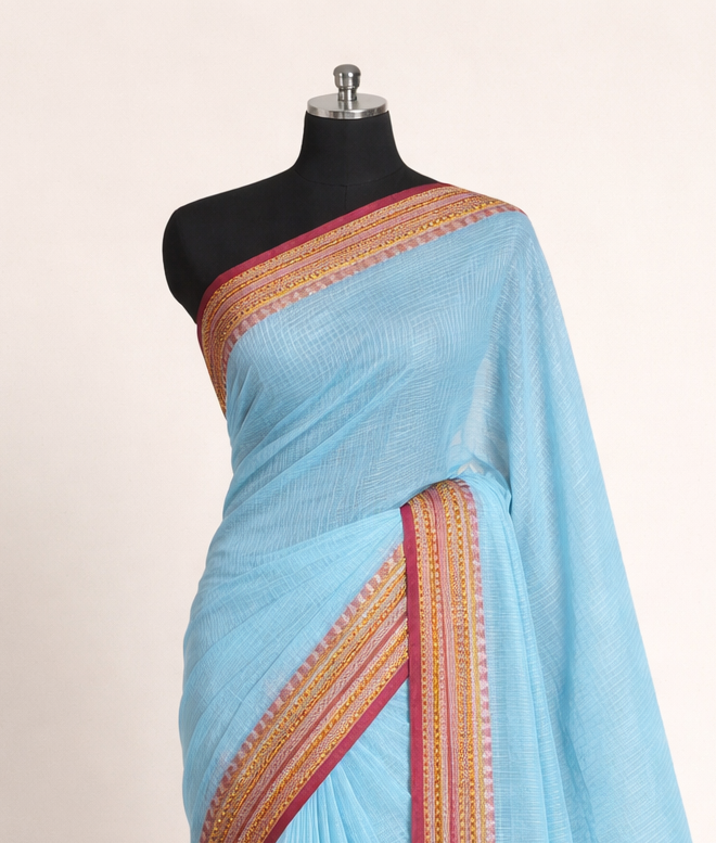 Light blue saree with a brown border on a mannequin against a white background
