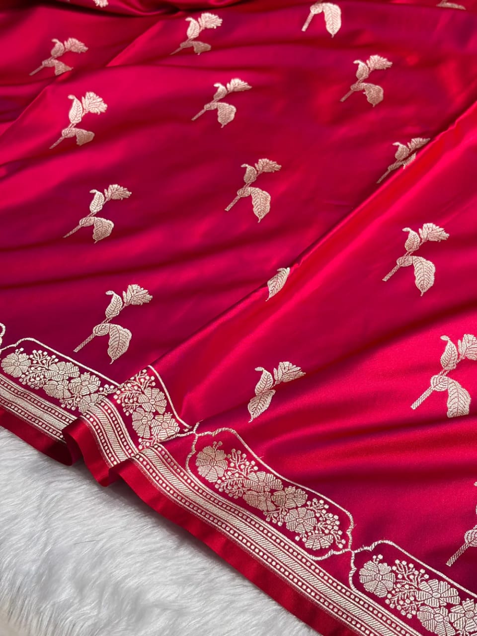 Red fabric with white floral embroidery on a white background