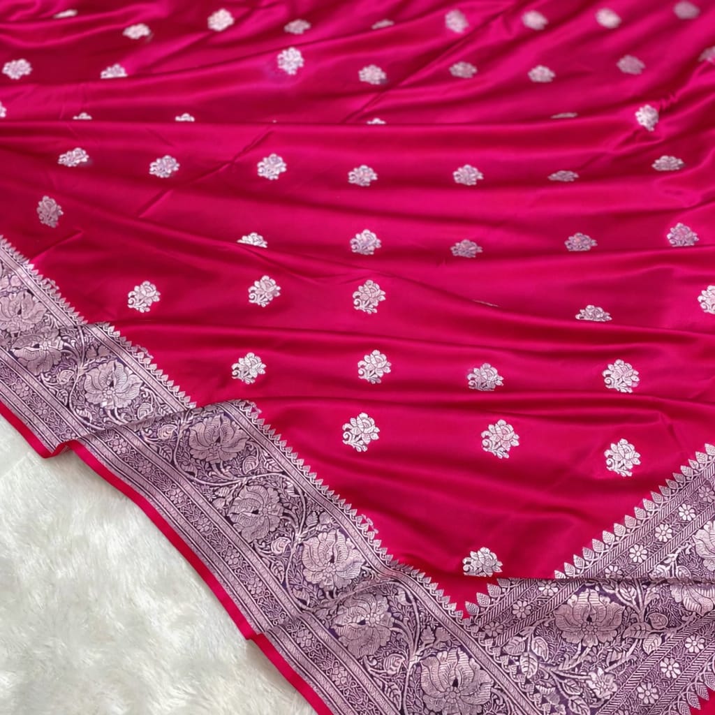 Pink saree with white floral patterns and a detailed purple border on a white background