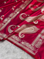 Red fabric with intricate white embroidery on a textured surface