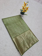 Green patterned fabric on a white surface with a small potted plant.
