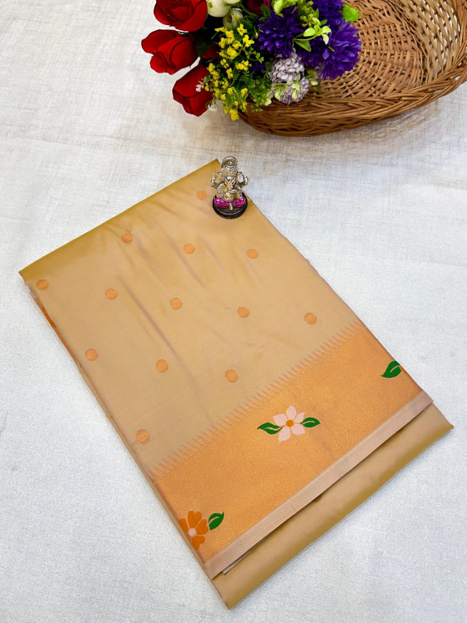 Beige saree with floral patterns on a white fabric background