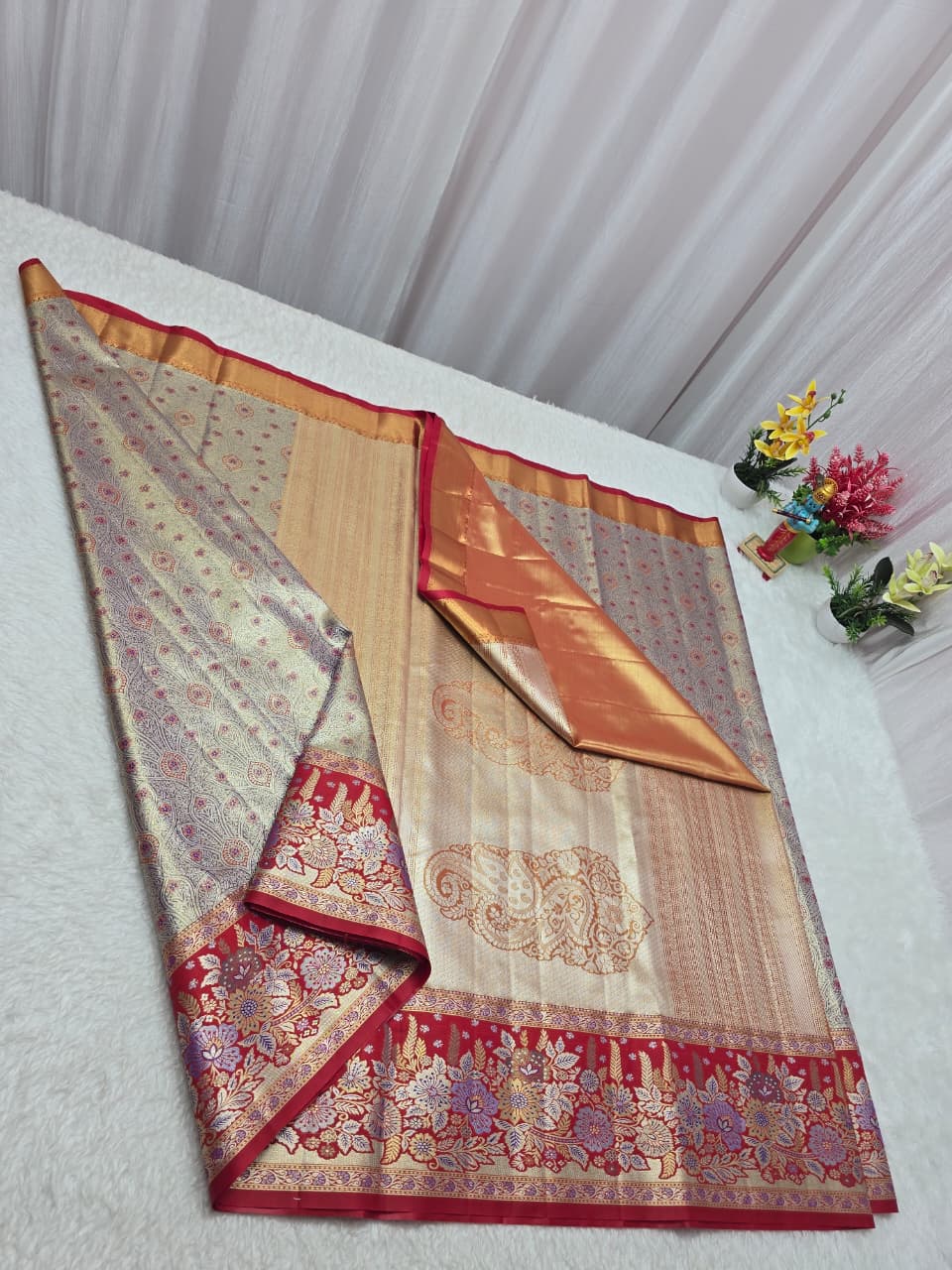 Traditional saree with intricate patterns on a white surface