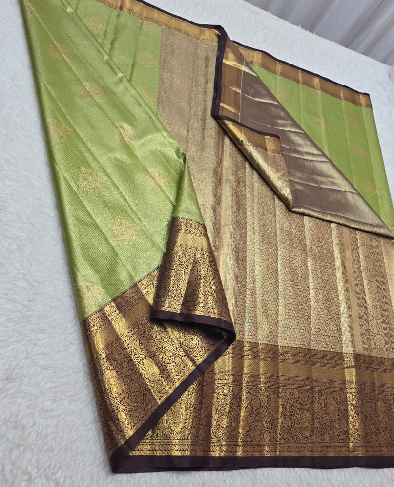 Green and brown saree with floral decorations in the background