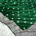 Green saree with silver floral patterns on a white background