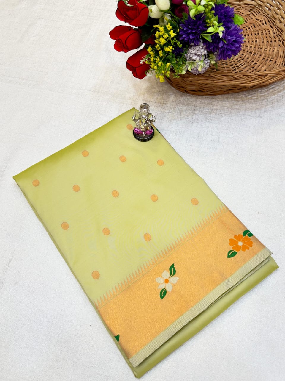 Yellow and green saree with floral patterns on a white background