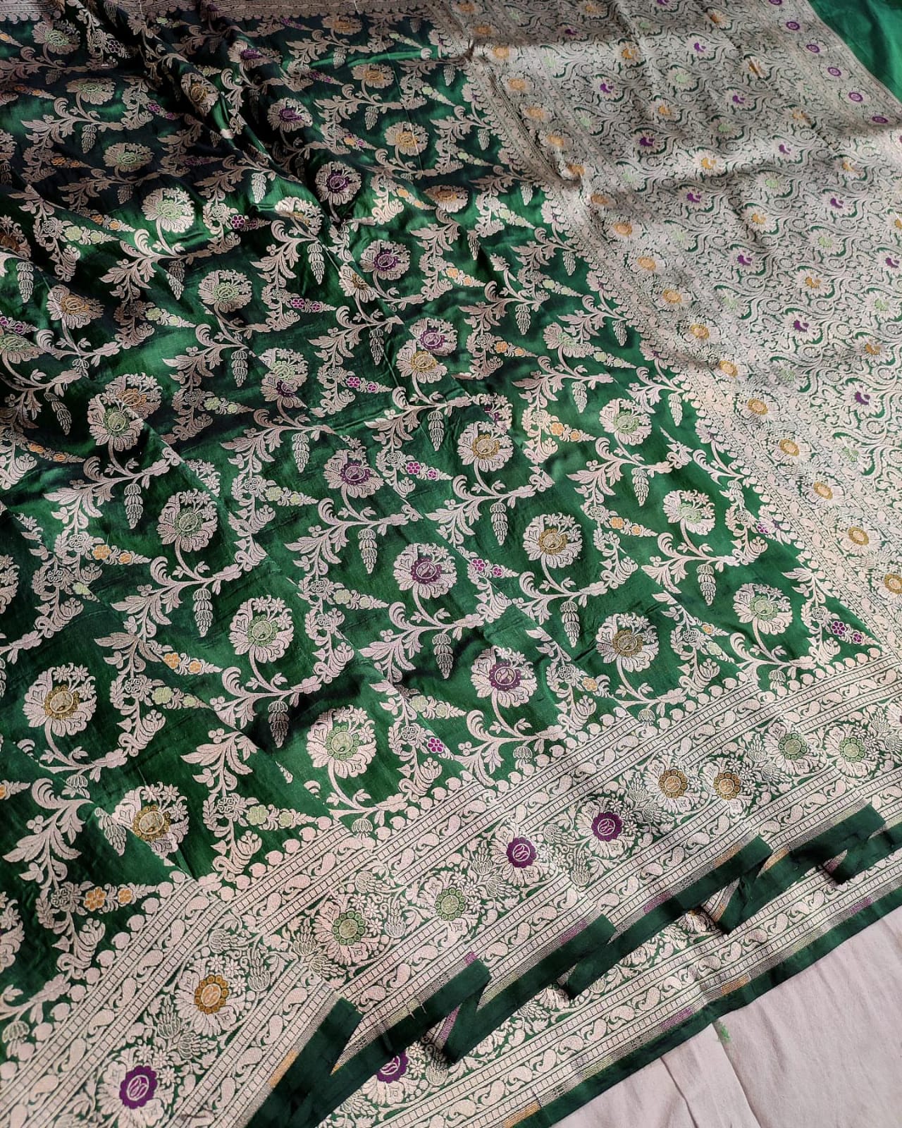 Green floral patterned fabric with intricate designs on a white background