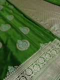 Green fabric with intricate white patterns on a textured surface