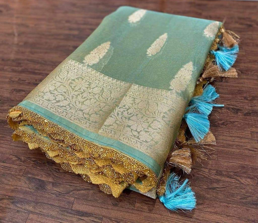 Traditional fabric with intricate patterns and tassels on a wooden surface
