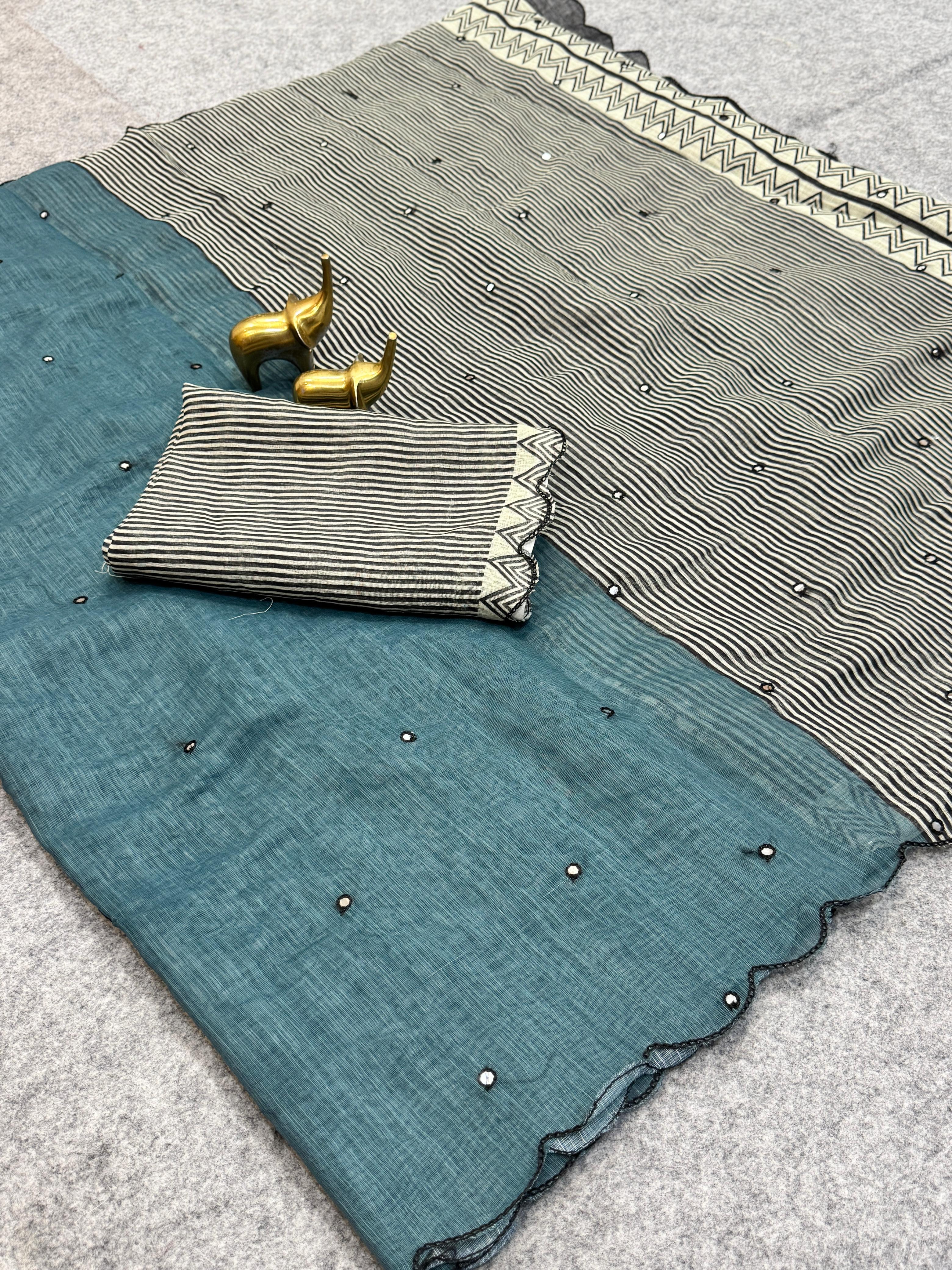 Teal fabric with black bead embellishments on a textured surface