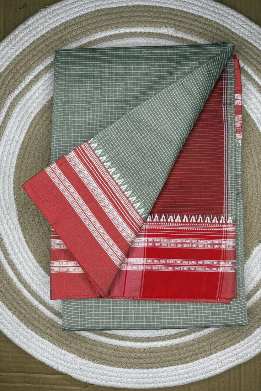 Two folded cloths, one green with white patterns and the other red with white patterns, on a woven surface.