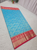 Blue saree with red border on a white surface