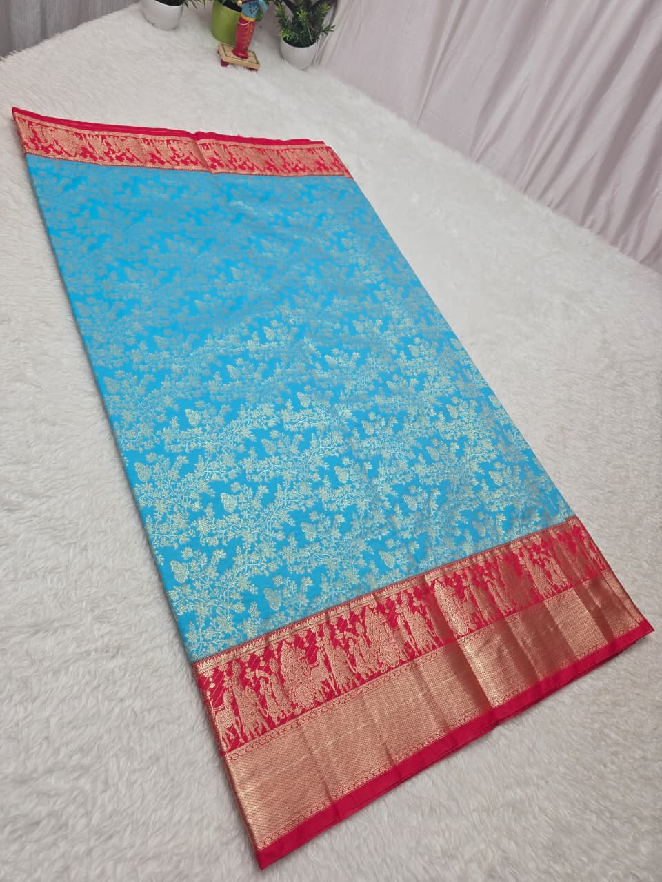 Blue saree with red border on a white surface