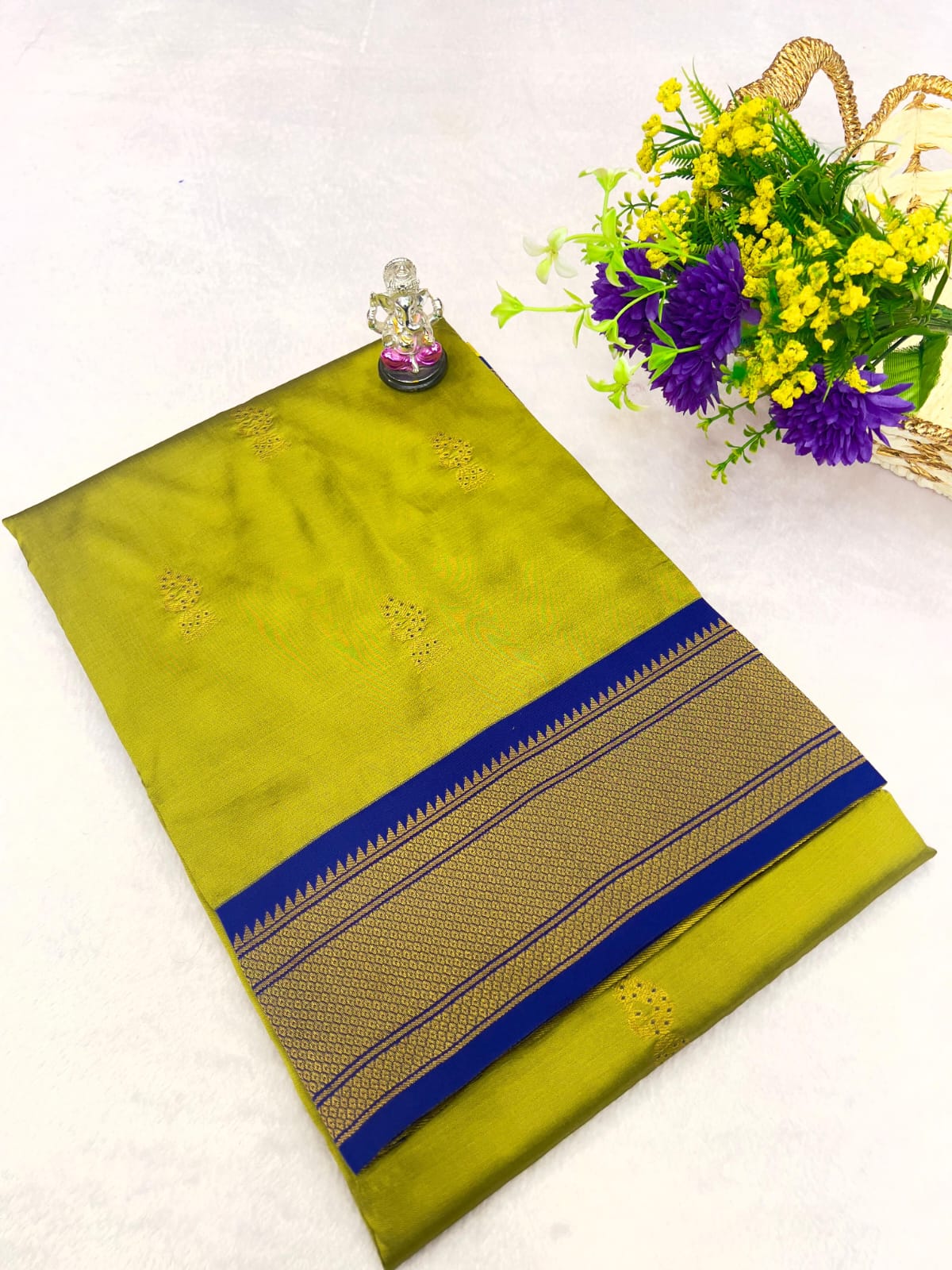 Green saree with a blue border on a white background